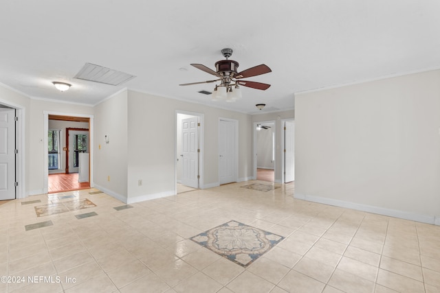 spare room featuring crown molding, visible vents, light tile patterned flooring, ceiling fan, and baseboards