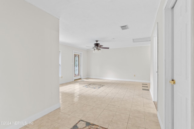 unfurnished room with visible vents, baseboards, ceiling fan, ornamental molding, and light tile patterned flooring