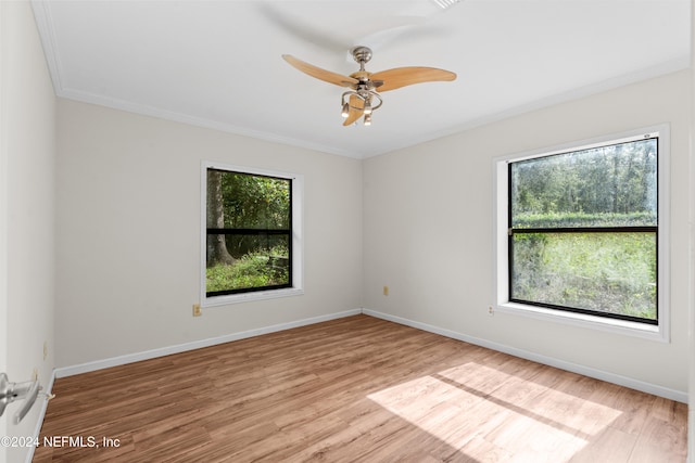 empty room with a ceiling fan, baseboards, wood finished floors, and ornamental molding