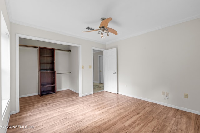 unfurnished bedroom featuring crown molding, a closet, light wood-type flooring, and ceiling fan