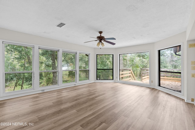 unfurnished sunroom with visible vents and ceiling fan