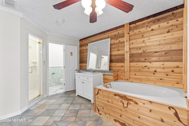 full bathroom featuring shower with separate bathtub, a textured ceiling, ceiling fan, wooden walls, and vanity