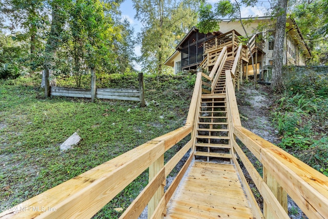 view of playground featuring a sunroom and a deck