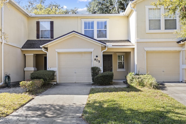 view of property with a front lawn and a garage