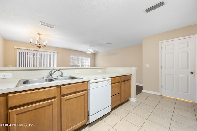 kitchen with pendant lighting, white dishwasher, ceiling fan with notable chandelier, sink, and light tile patterned floors