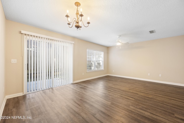 spare room with a textured ceiling, ceiling fan with notable chandelier, and dark wood-type flooring