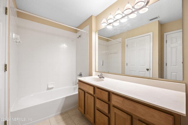 bathroom featuring tile patterned flooring, a textured ceiling, and tiled shower / bath