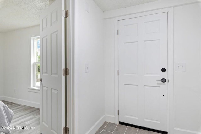 entryway featuring light hardwood / wood-style floors and a textured ceiling