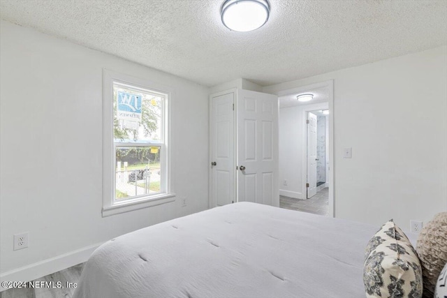 bedroom featuring a textured ceiling and light wood-type flooring