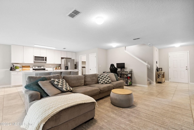 tiled living room featuring a textured ceiling