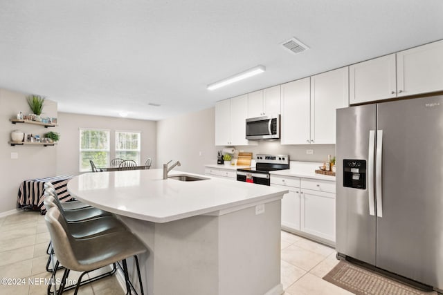 kitchen featuring white cabinets, a kitchen island with sink, stainless steel appliances, and light tile patterned floors