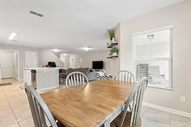 dining space with sink and light tile patterned floors