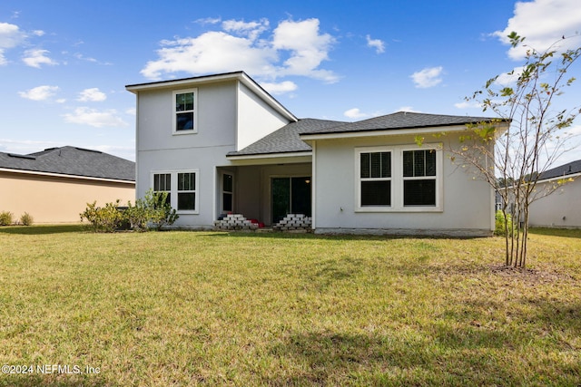 rear view of property with a lawn