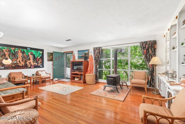 living room featuring a wood stove and wood-type flooring