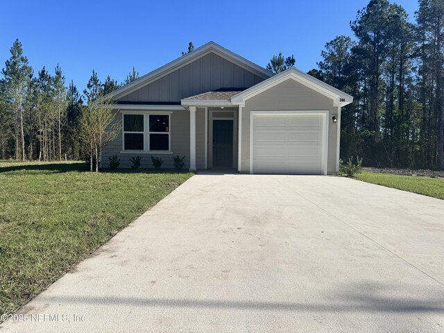 744 Hunter Rd, Hollister, FL 32177 - ranch-style home featuring concrete driveway, board and batten siding, a garage, and a front lawn