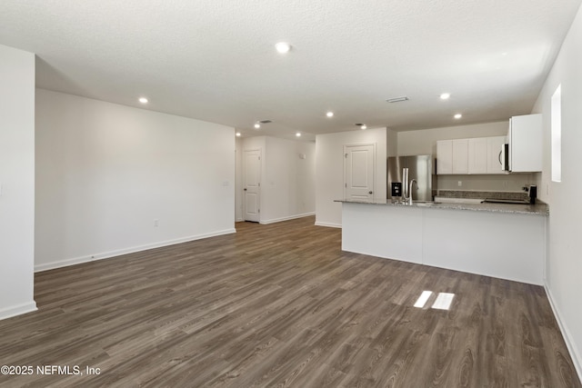 744 Hunter Rd, Hollister, FL 32177 - kitchen featuring stainless steel refrigerator with ice dispenser, dark wood finished floors, recessed lighting, a peninsula, and white cabinets