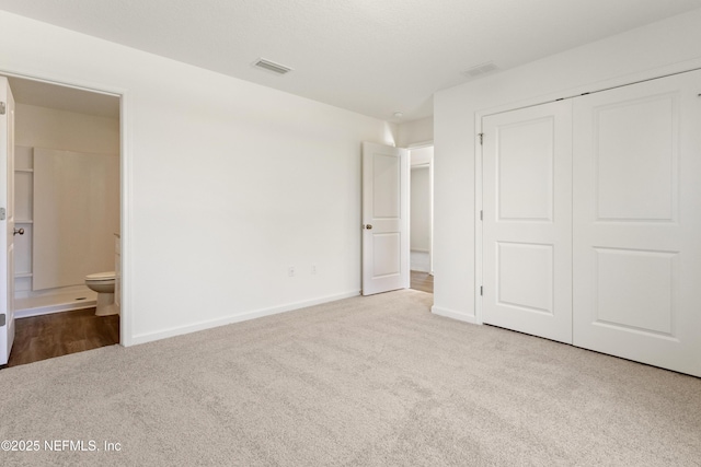 744 Hunter Rd, Hollister, FL 32177 - unfurnished bedroom with carpet, a closet, baseboards, and connected bathroom