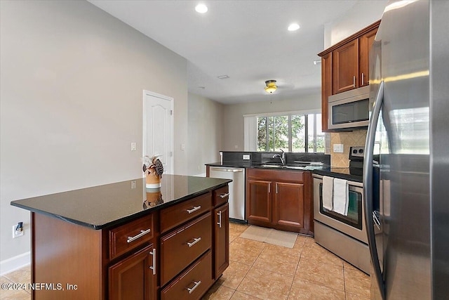 kitchen with light tile patterned floors, backsplash, stainless steel appliances, sink, and a center island