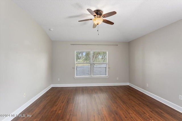 empty room with dark hardwood / wood-style floors, a textured ceiling, and ceiling fan