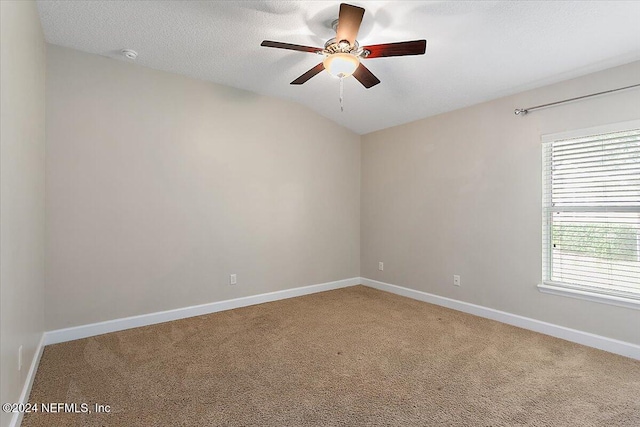 carpeted spare room with ceiling fan, a textured ceiling, and lofted ceiling