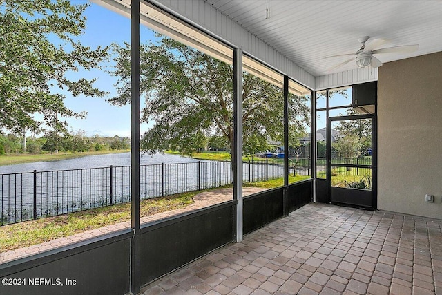 unfurnished sunroom featuring a water view and ceiling fan