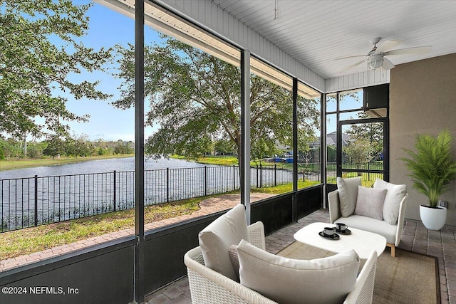 sunroom / solarium with a water view and ceiling fan