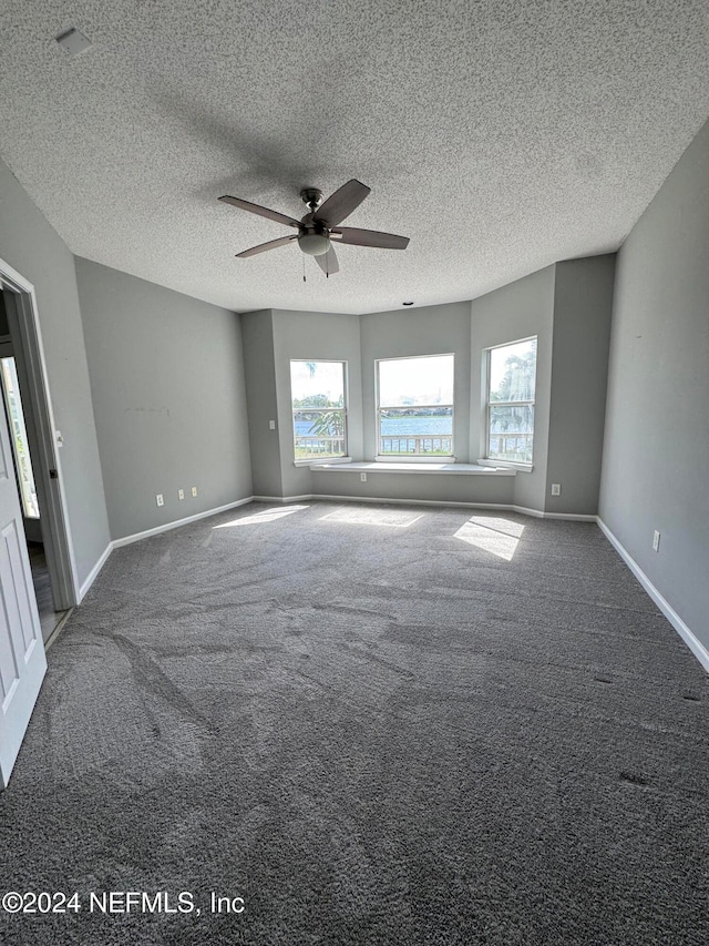 carpeted empty room featuring a textured ceiling and ceiling fan