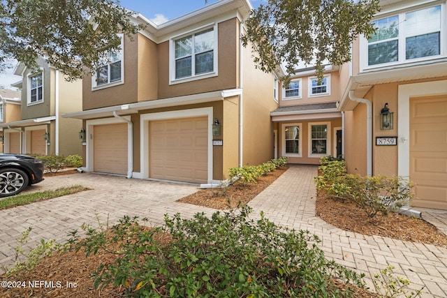 multi unit property featuring decorative driveway, an attached garage, and stucco siding