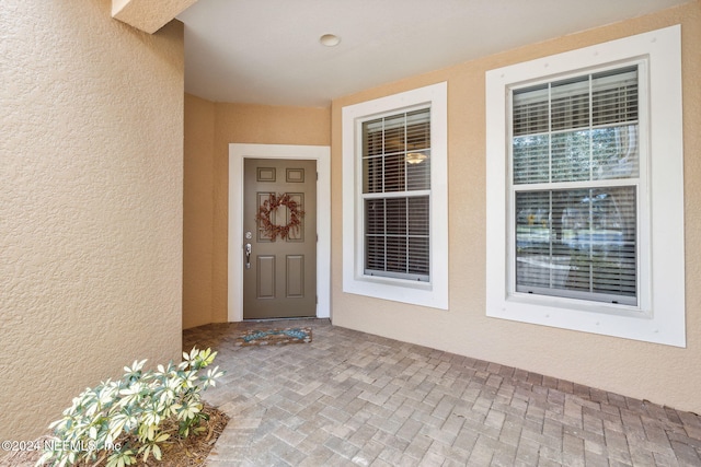 doorway to property featuring stucco siding