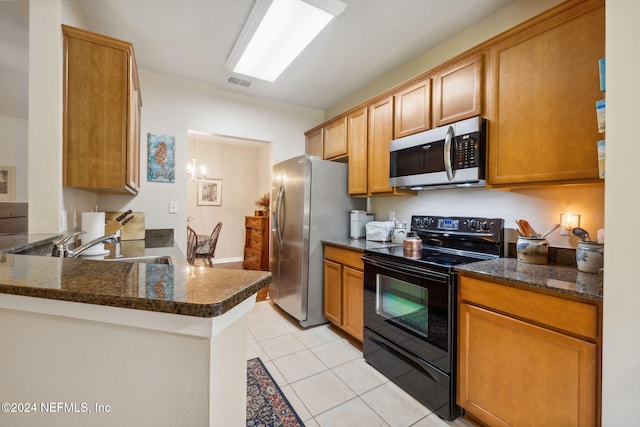 8757 Little Swift Cir Unit 22F, Jacksonville, FL 32256 - kitchen with stainless steel appliances, light tile patterned floors, a peninsula, and brown cabinets