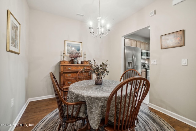 dining room with dark wood-style floors, a notable chandelier, visible vents, and baseboards