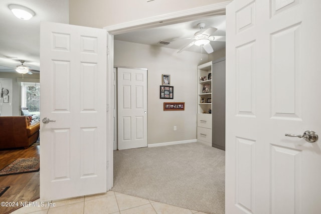 interior space featuring light carpet, visible vents, baseboards, and light tile patterned flooring