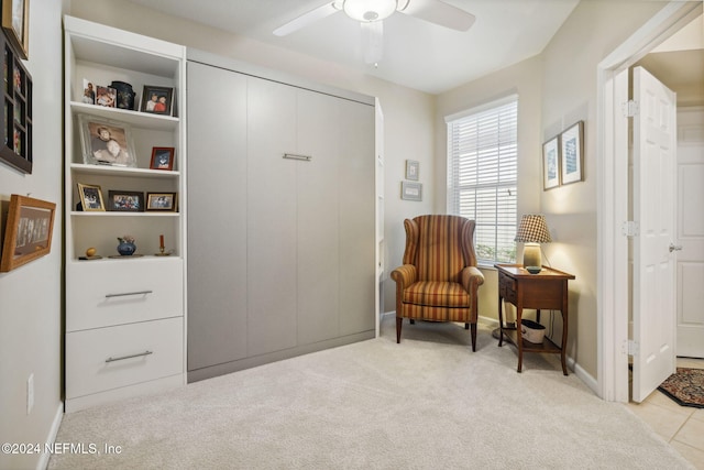 living area featuring carpet floors, ceiling fan, and baseboards