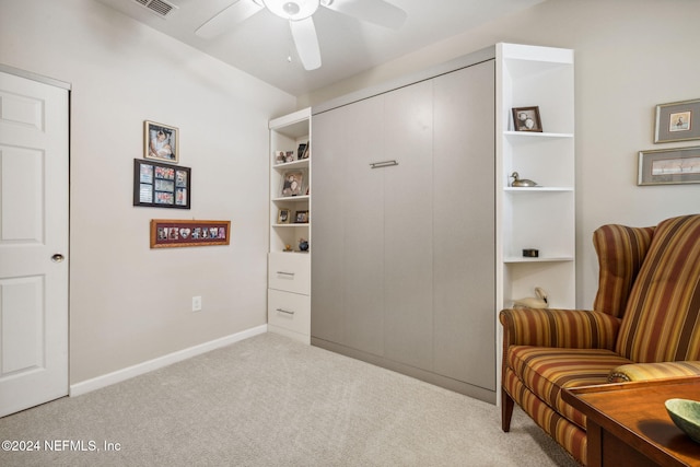 living area featuring ceiling fan, baseboards, and carpet flooring