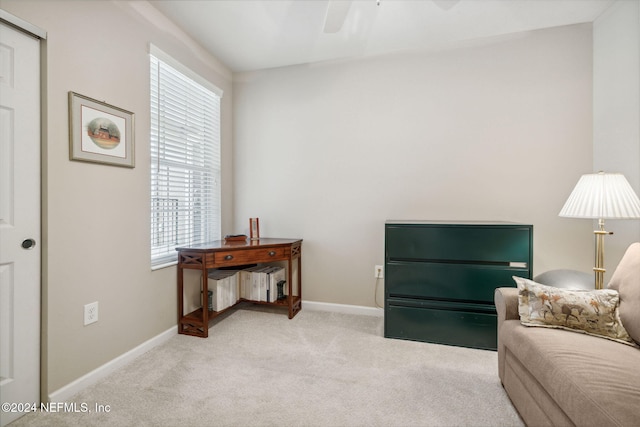 living area with light carpet and ceiling fan