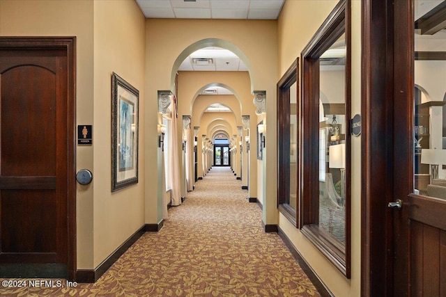 8757 Little Swift Cir Unit 22F, Jacksonville, FL 32256 - hallway with carpet, a drop ceiling, baseboards, and arched walkways