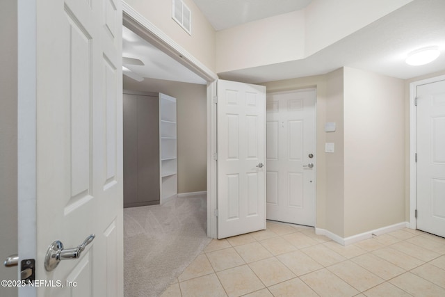 entrance foyer featuring light colored carpet, visible vents, baseboards, and light tile patterned floors