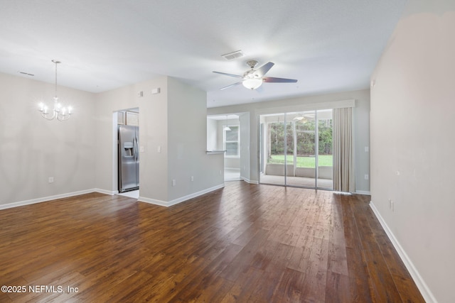 unfurnished living room with ceiling fan with notable chandelier, dark wood-style flooring, visible vents, and baseboards