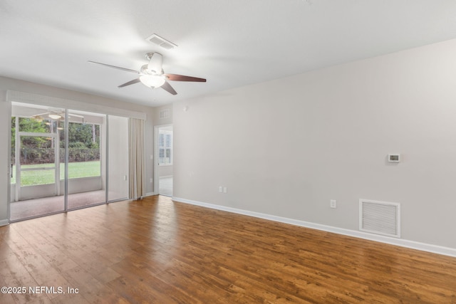 empty room with a ceiling fan, baseboards, visible vents, and wood finished floors