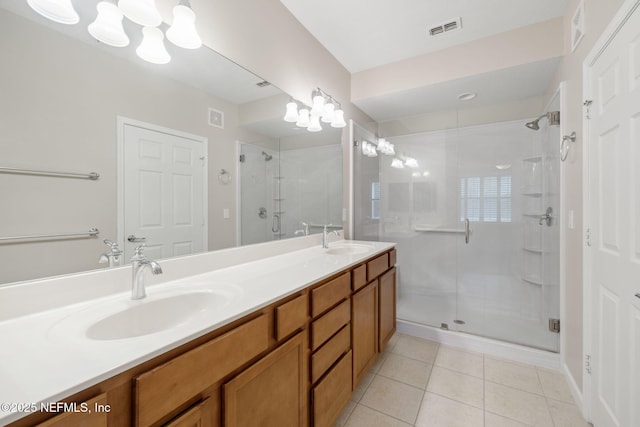 bathroom featuring visible vents, a sink, a shower stall, and tile patterned floors