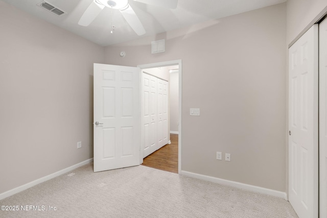 unfurnished bedroom featuring carpet floors, baseboards, visible vents, and a closet