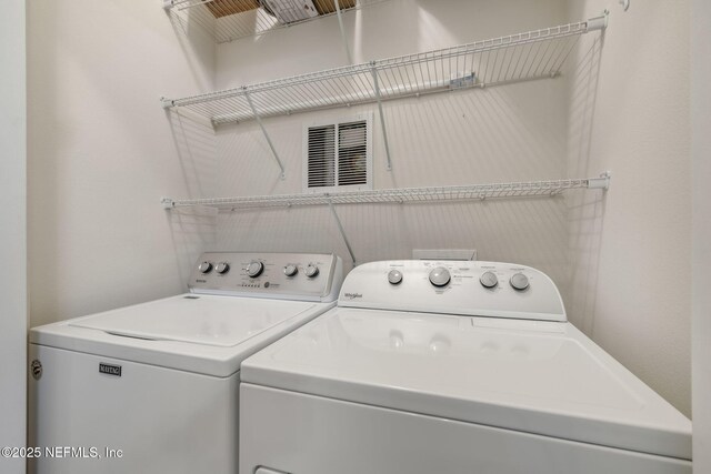 clothes washing area with washer and clothes dryer