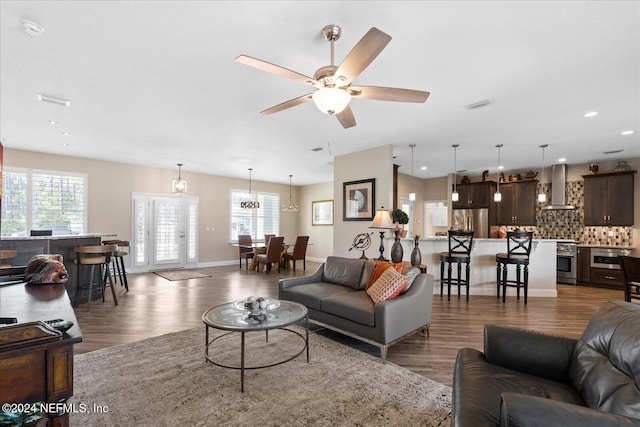 living room with dark hardwood / wood-style floors and ceiling fan with notable chandelier