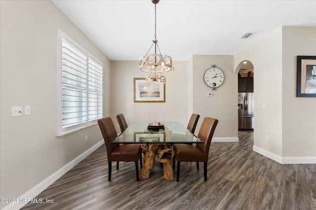 dining area with an inviting chandelier and dark hardwood / wood-style flooring