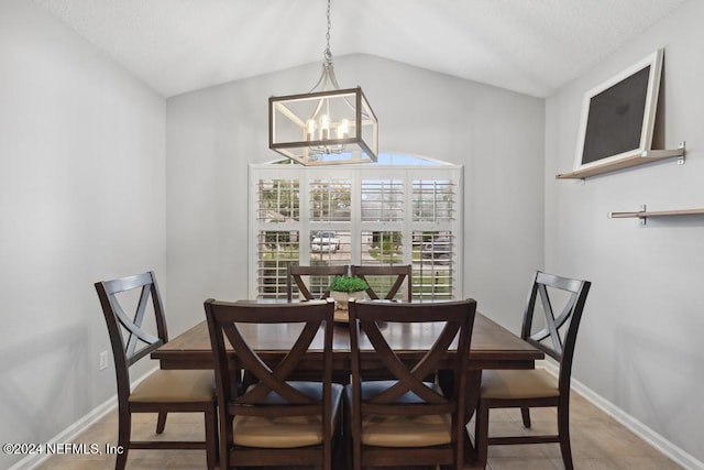 dining area featuring a chandelier, tile patterned floors, and vaulted ceiling