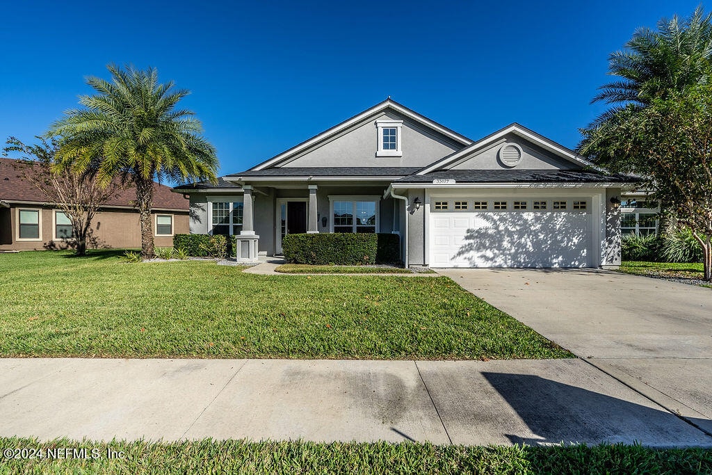 ranch-style home with a front yard and a garage