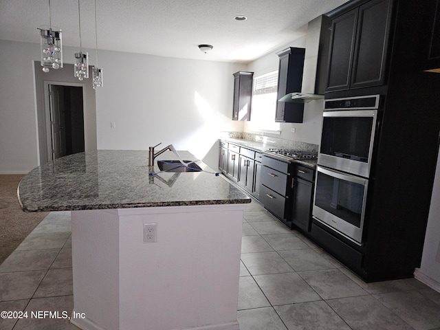 kitchen featuring light tile patterned floors, stone countertops, sink, stainless steel appliances, and a center island