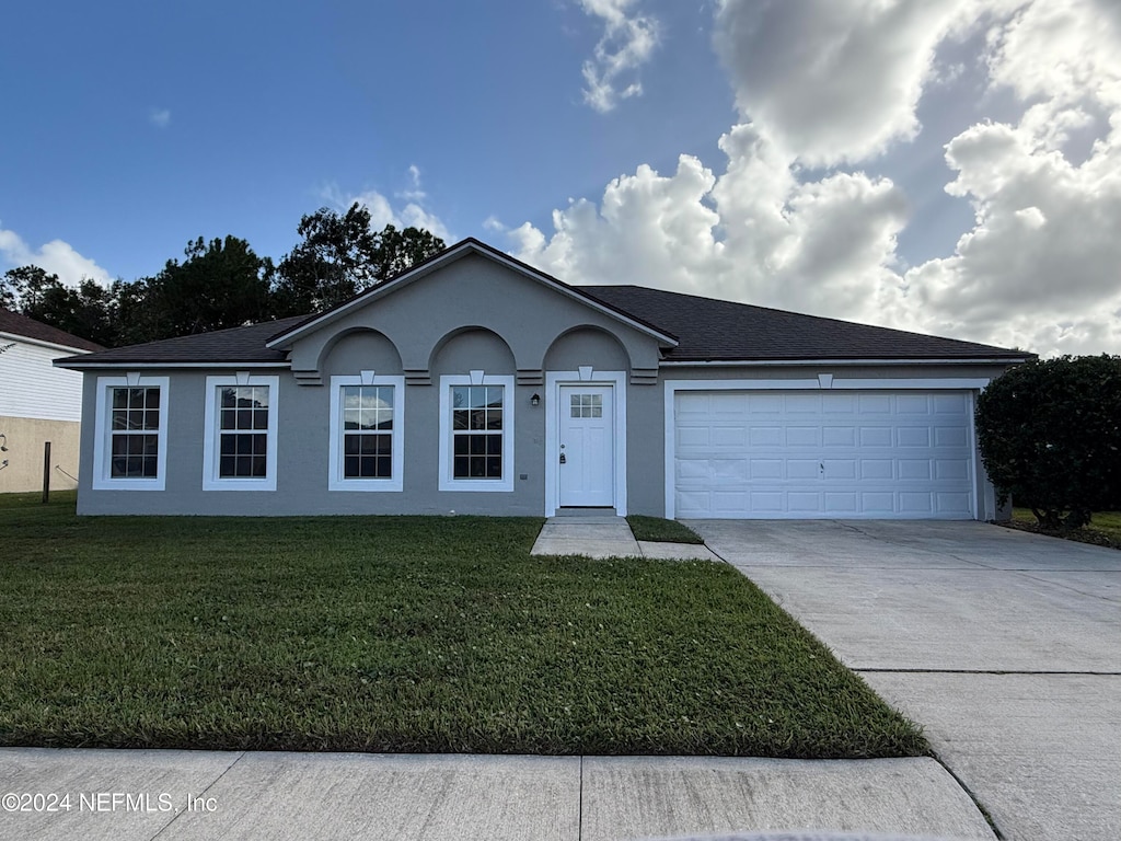 ranch-style house featuring a front yard and a garage