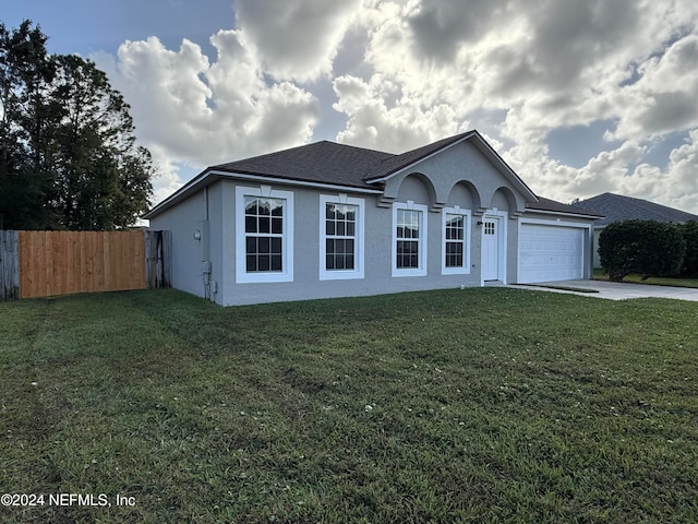 ranch-style house featuring a front lawn and a garage