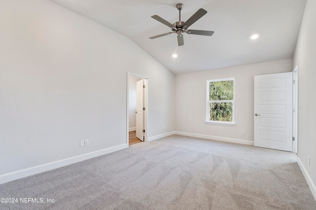 unfurnished bedroom with ensuite bathroom, lofted ceiling, light colored carpet, and ceiling fan